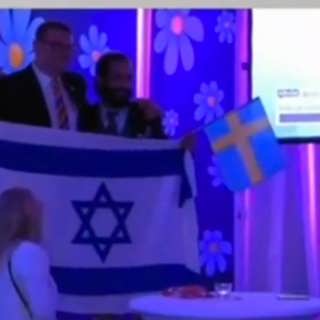 Vem är mannen med Israel-flaggan på SD:s valvaka?